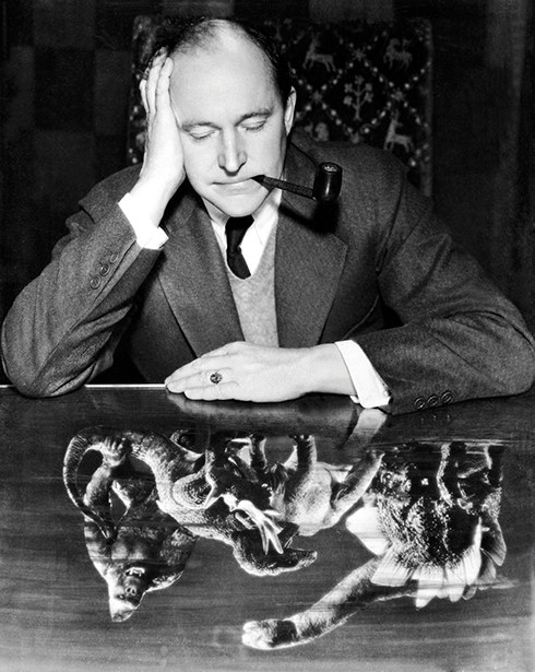 Black-and-white portrait of a man in a suit with a pipe, head resting on his hand, above a montage of a giant ape wrestling a dinosaur